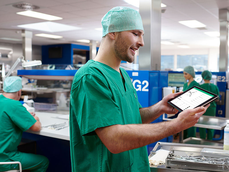 Infirmier au bloc opératoire et Unité Centrale de Stérilisation avec un outil de gestion de l’organisation des plateaux d'instruments sur sa tablette