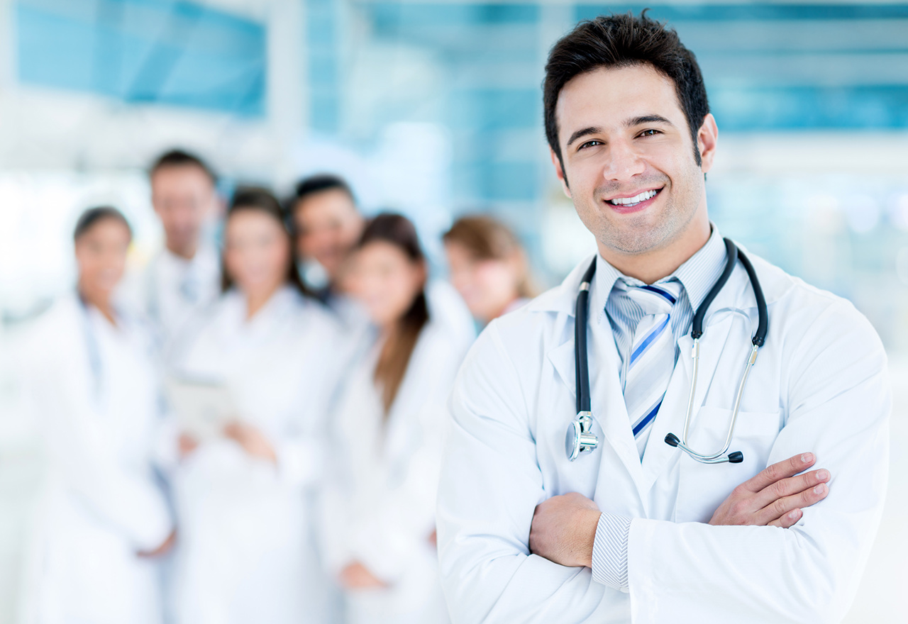Happy doctor with medical staff at the hospital 
